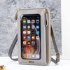 A light beige hands-free crossbody phone bag with a clear window showing a smartphone and card slots.