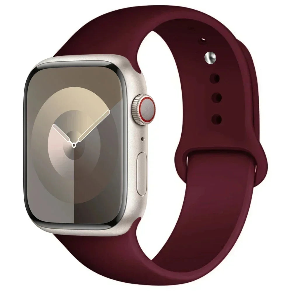 A silver Apple Watch is shown attached to a dark maroon silicone sport band.