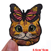 Embroidered patch of a cartoon cat butterfly with orange and black fur and pink wings