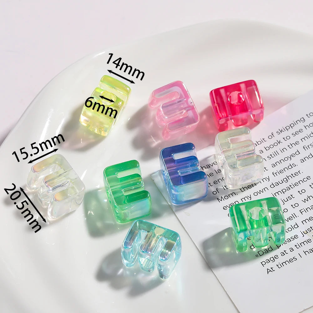 A collection of colorful acrylic alphabet beads displayed on a white plate with measurement lines.