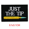 Black embroidered iron-on letter patch with white text JUST THE TIP and a yellow pencil on it.