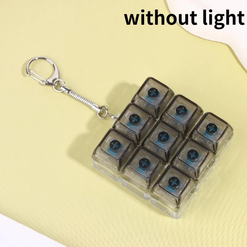 A clear plastic fidget toy keychain with multiple dark blue LED keycaps and a silver keyring.