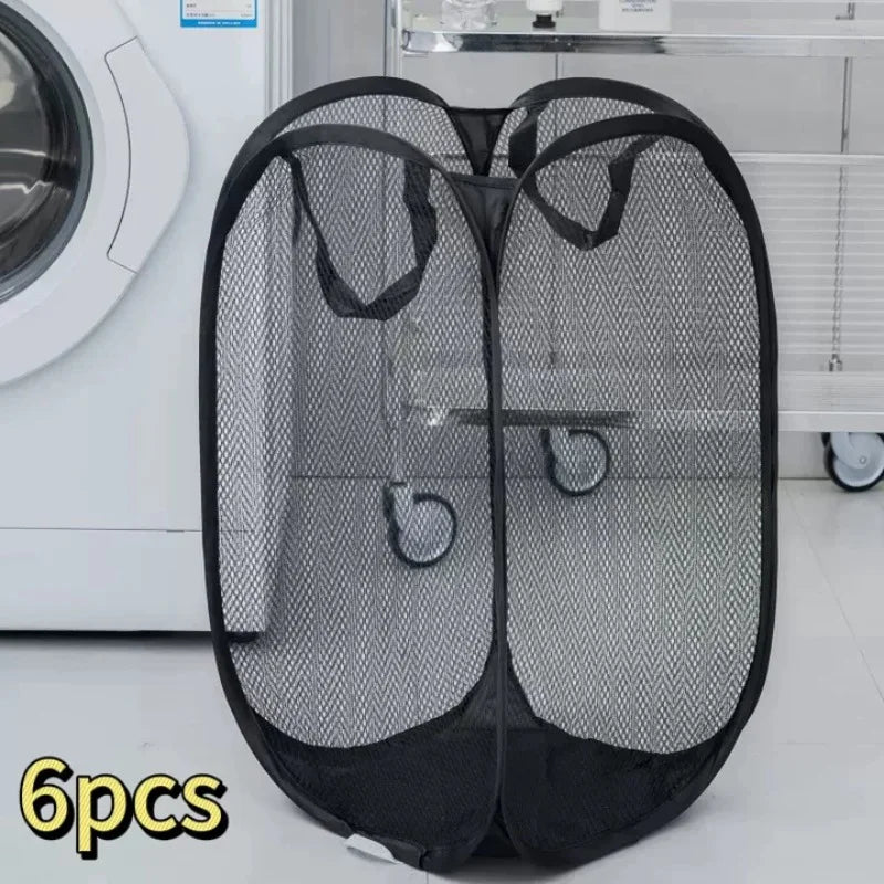 A black foldable mesh laundry basket with handles is shown next to a white washing machine.