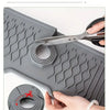 A hand cuts a silicone kitchen sink mat according to the size of the faucet using extendable slit cutting tool.