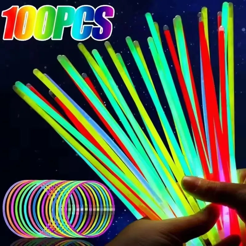 A hand holds a bundle of bright, bendable glow sticks with vibrant colors against a dark background.