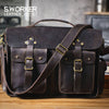 Dunkelbraunes Vintage-Ledertasche mit Messing-Hardware und Lederriemen auf Holzoberfläche