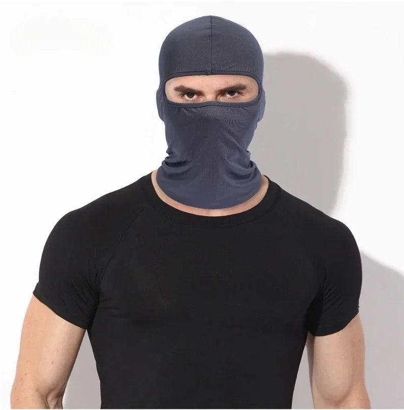 A man wearing a dark blue windproof full face balaclava and a black t-shirt.