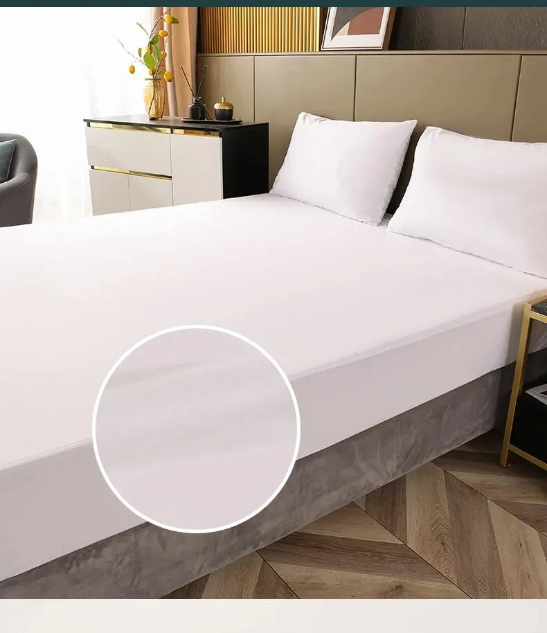 A white fitted mattress protector is shown on a bed, with a close-up view of the elastic edge.