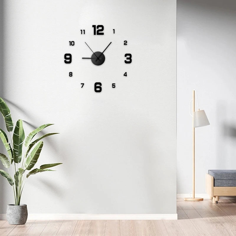 A black analog wall clock with a white face and black numbers is mounted on a white wall.