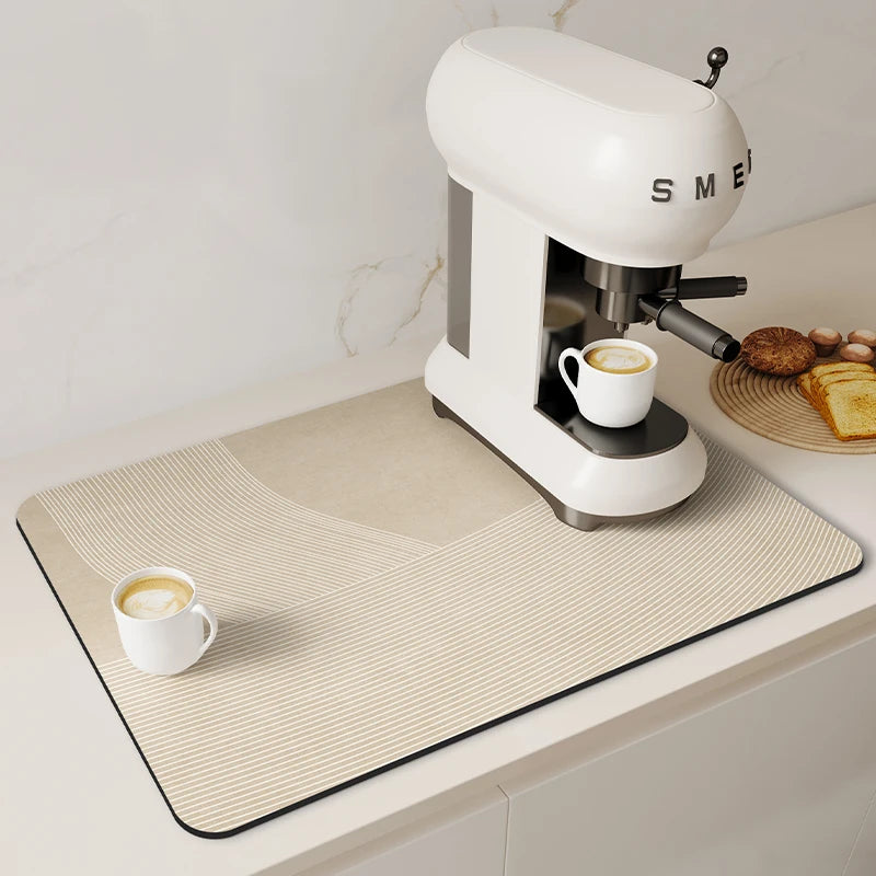 A white espresso machine is placed on a beige striped counter mat with coffee cups and bread visible.