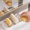 Stainless steel soap holder with W-shaped soap bars and drainage tray on a marble surface