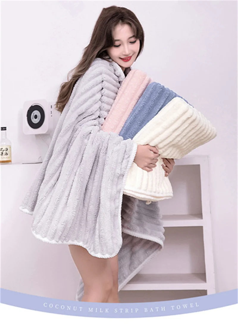 A woman is holding a light gray coconut milk strip bath towel in a casual pose against a white background.