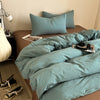 A teal striped duvet cover set with matching pillowcases is displayed on a bed.