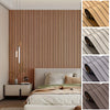 Close-up view of wood slat peel-and-stick wall panels installed on a bedroom wall and rolled up examples.