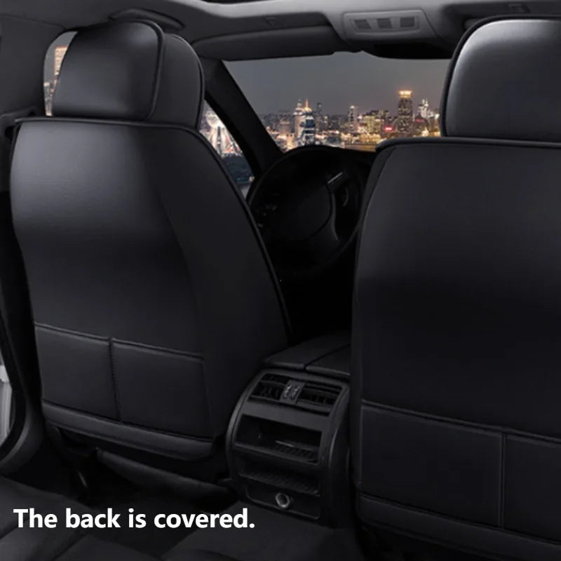 Interior view of a car showing black PU leather seat covers and dashboard.