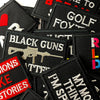 A collection of black embroidered iron-on patches featuring text like BLACK GUNS and GOLF.