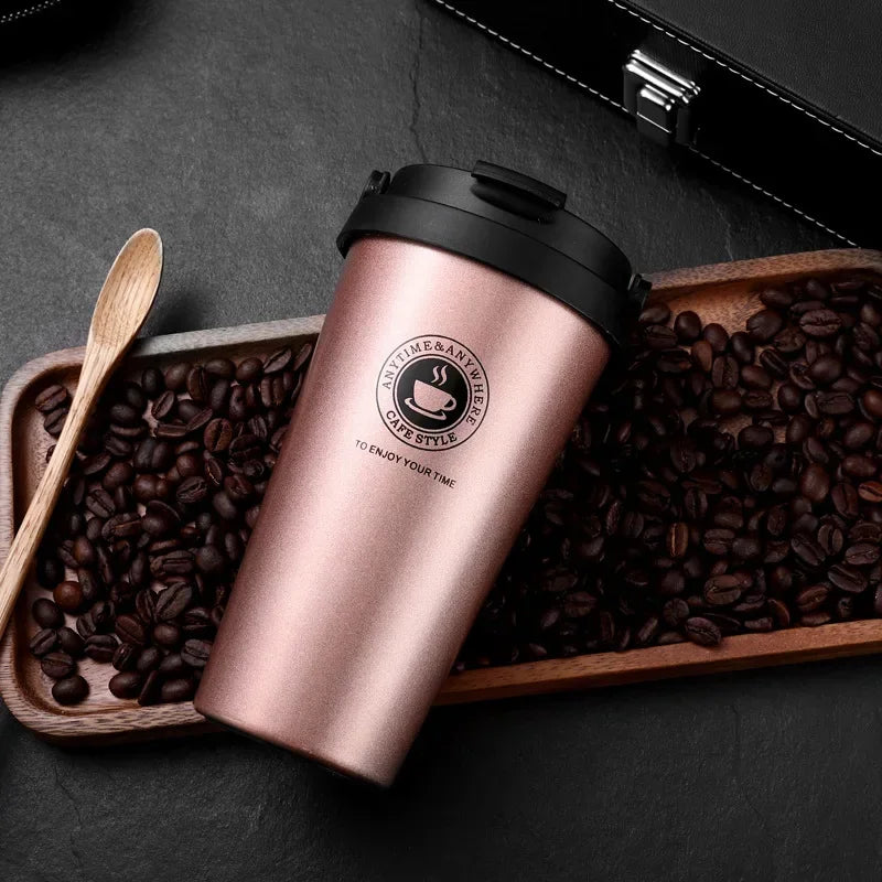 Pinke doppelwandige isolierte Reise-Kaffeetasse gefüllt mit Kaffeebohnen, auf einem Holztablett.