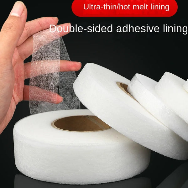 Eine Hand trägt ultrafeine Hot Melt-Laminierungstape auf eine weiße Rolle für Kleidungsinterlining.