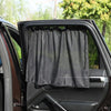 A black universal car side window sunshade is installed in a vehicle door frame.