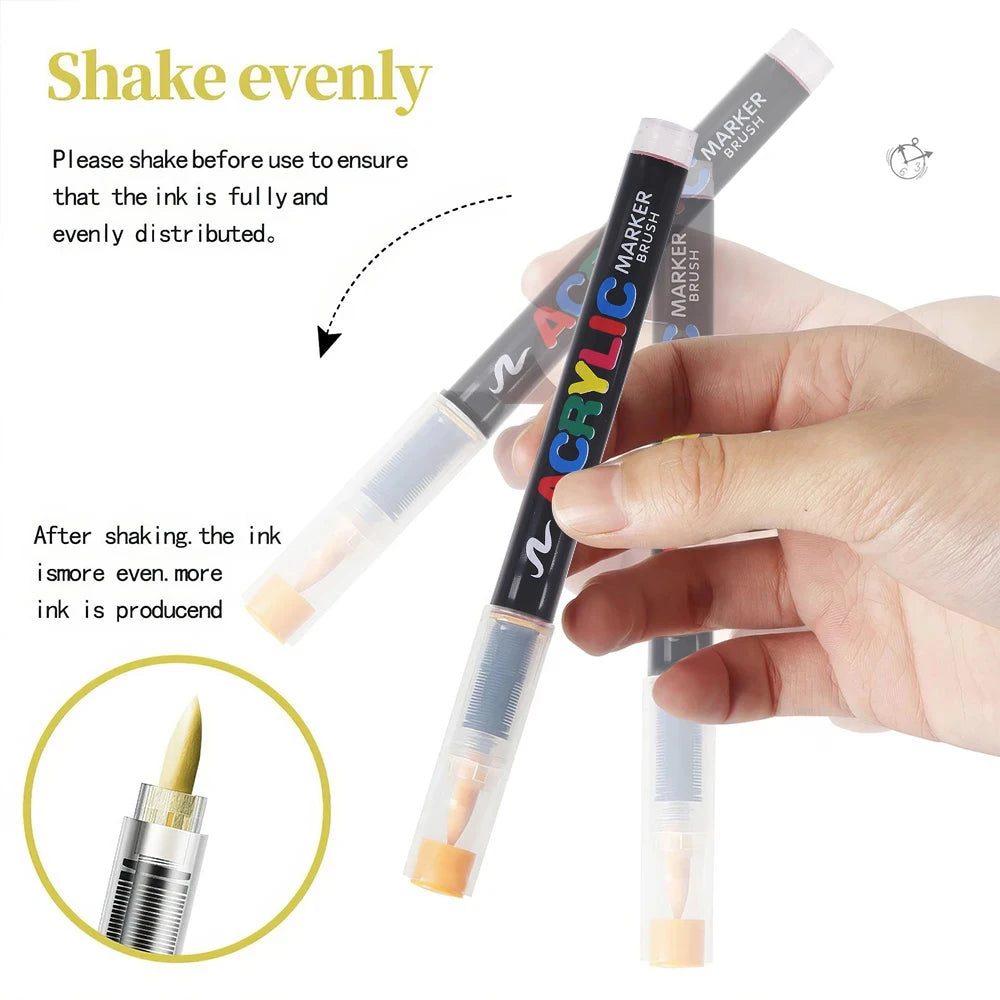 A hand is shaking a set of black acrylic paint marker brushes to ensure the ink is evenly distributed.