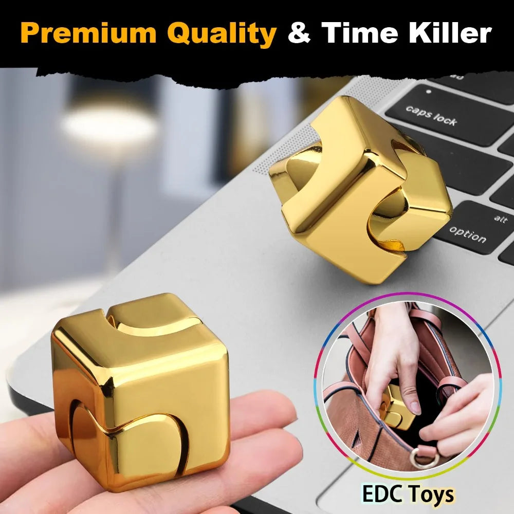 A gold alloy metal fidget cube spinner toy is shown on a laptop and in a hand.