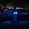 Interior view of a car showing a dashboard with an infotainment screen and steering wheel, illuminated by blue LED strips.