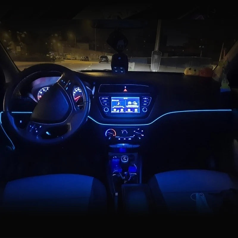 Interior view of a car showing a dashboard with an infotainment screen and steering wheel, illuminated by blue LED strips.