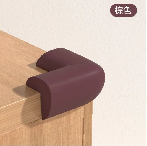 A close-up of a dark purple soft baby corner guard placed on a wooden cabinet surface.