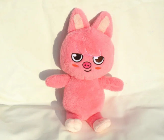 A pink, fluffy plush doll shaped like a pig with large ears and cute facial features.