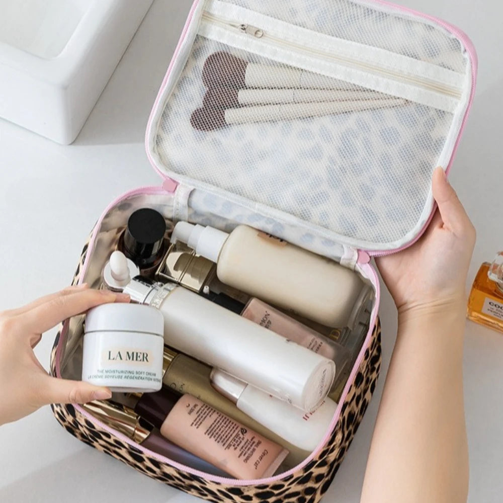 A hand opens a leopard print toiletry bag revealing various skincare products inside.