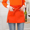 An orange half apron with tie closure and pockets worn by a person.