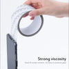 A hand is applying a self-adhesive mesh repair patch to the screen of a smartphone.