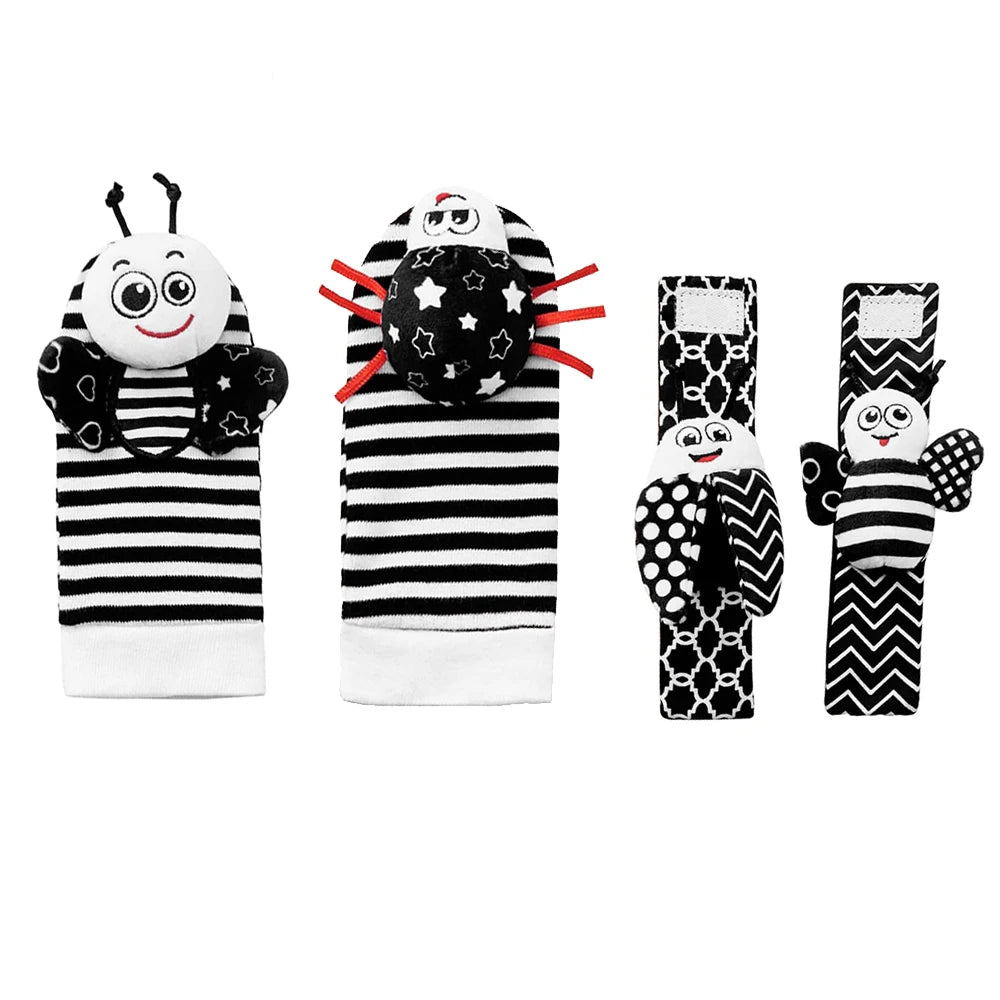 A set of soft baby rattles featuring a black and white striped fabric with attached wrist and foot finders.