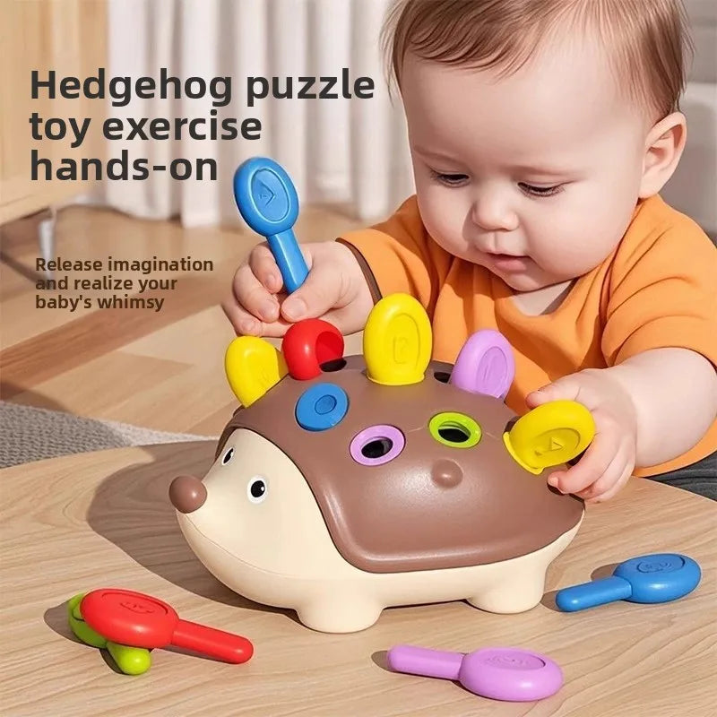 Ein Baby interagiert mit einem braunen Erdgerechte-Sensorspielzeug und bunten Silikonwerkzeugen zur Feinmotorikübung.