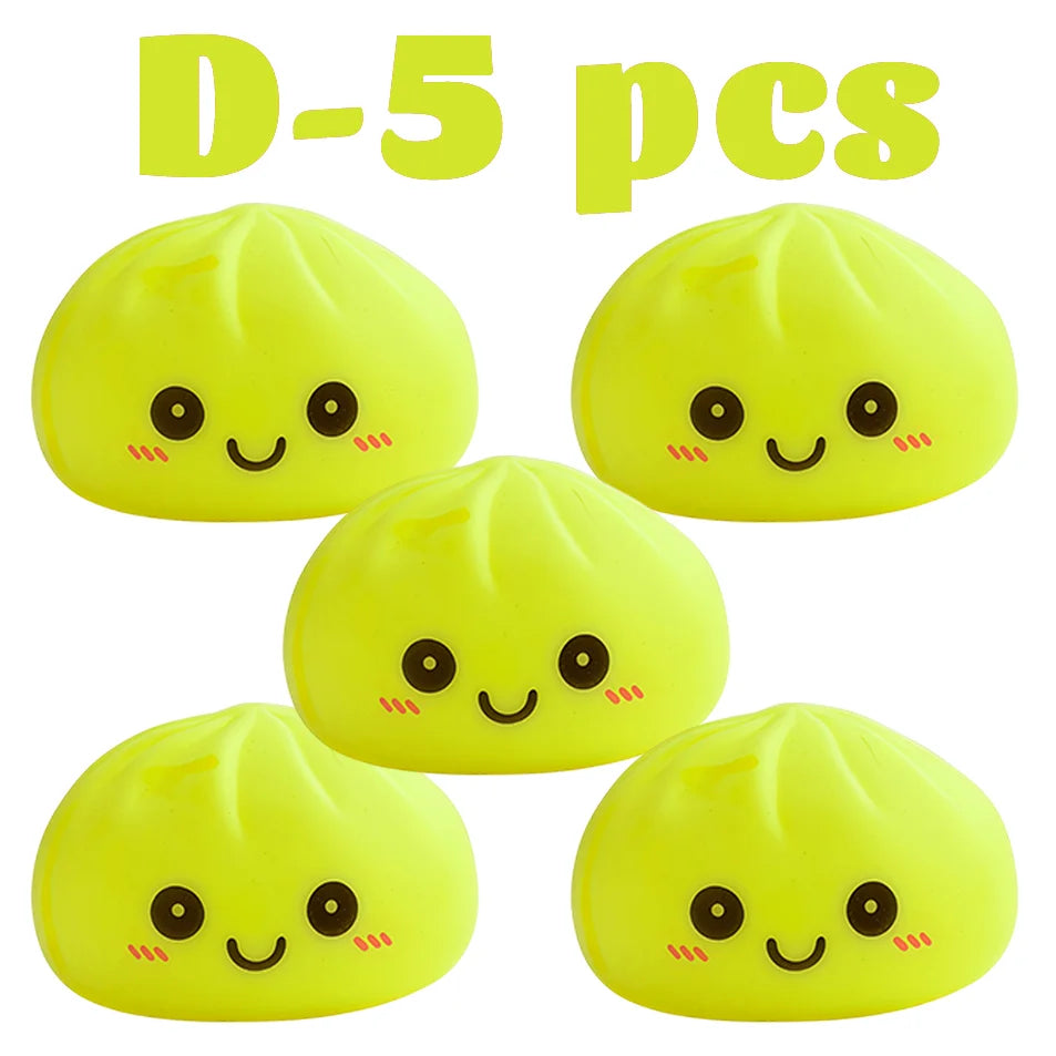 Cinco juguetes de dumplings brillantes y amarillos que brillan, dispuestos en fila.