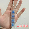 A hand holds a clear plastic keychain fidget toy with blue LED lights inside.