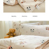 A beige lace-trimmed breathable summer duvet is folded on a bed with pillows and a teddy bear.