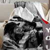 A photo of a couple smiling while looking at a map, printed on a flannel blanket.
