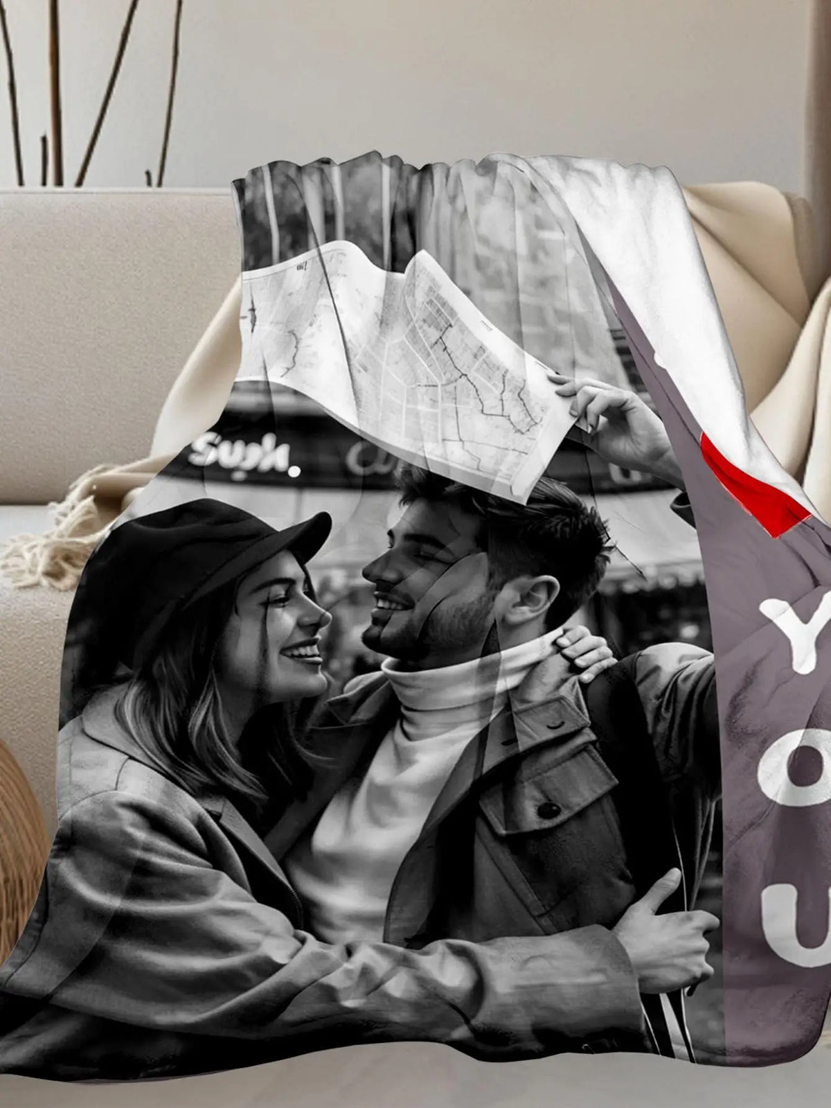 A photo of a couple smiling while looking at a map, printed on a flannel blanket.