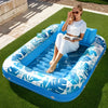 Eine Frau entspannt auf einem blauen aufblasbaren Poolschwimmhilfe auf grünem Gras in der Sonne.