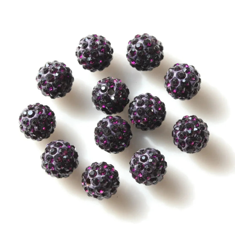 A scattering of dark purple crystal clay round beads for DIY jewelry and craft projects