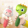 A hand is holding a green cartoon animal rattle toy for baby sensory development.