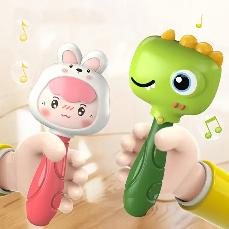 A hand is holding a green cartoon animal rattle toy for baby sensory development.