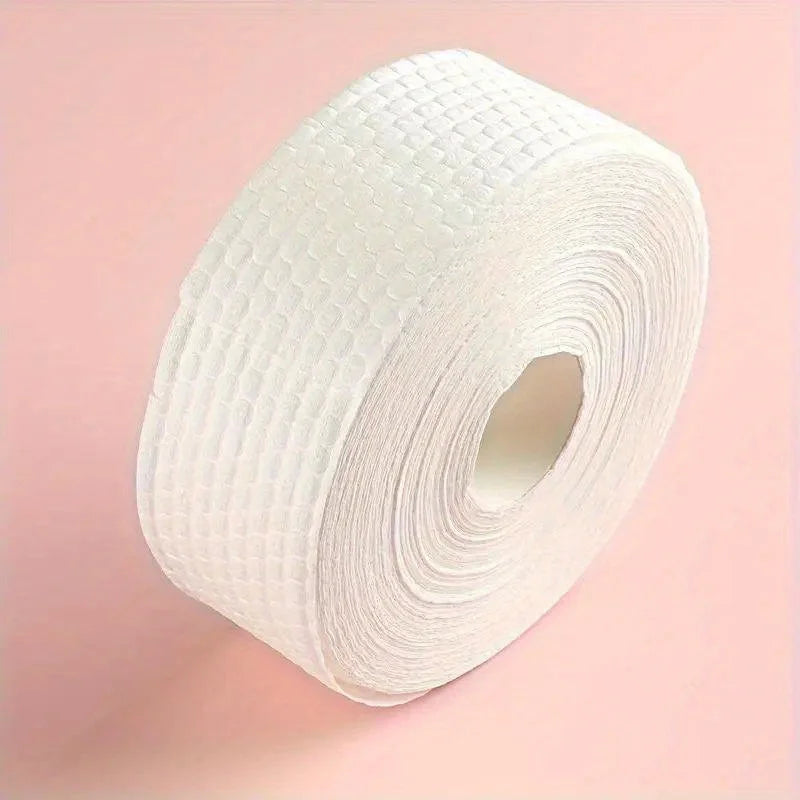 A roll of white lint-free cotton rounds for nail care against a pink background.