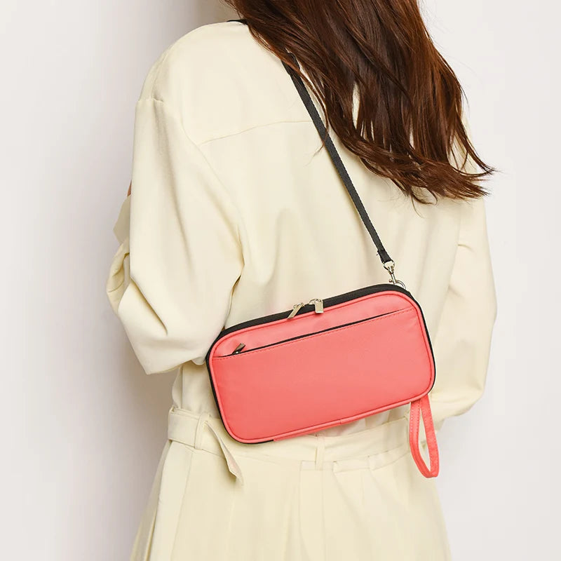 A woman is holding a pink waterproof passport and document organizer wallet against a light beige jacket.