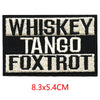 Black embroidered iron-on letter patches with white text reading Whiskey Tango and Foxtrot