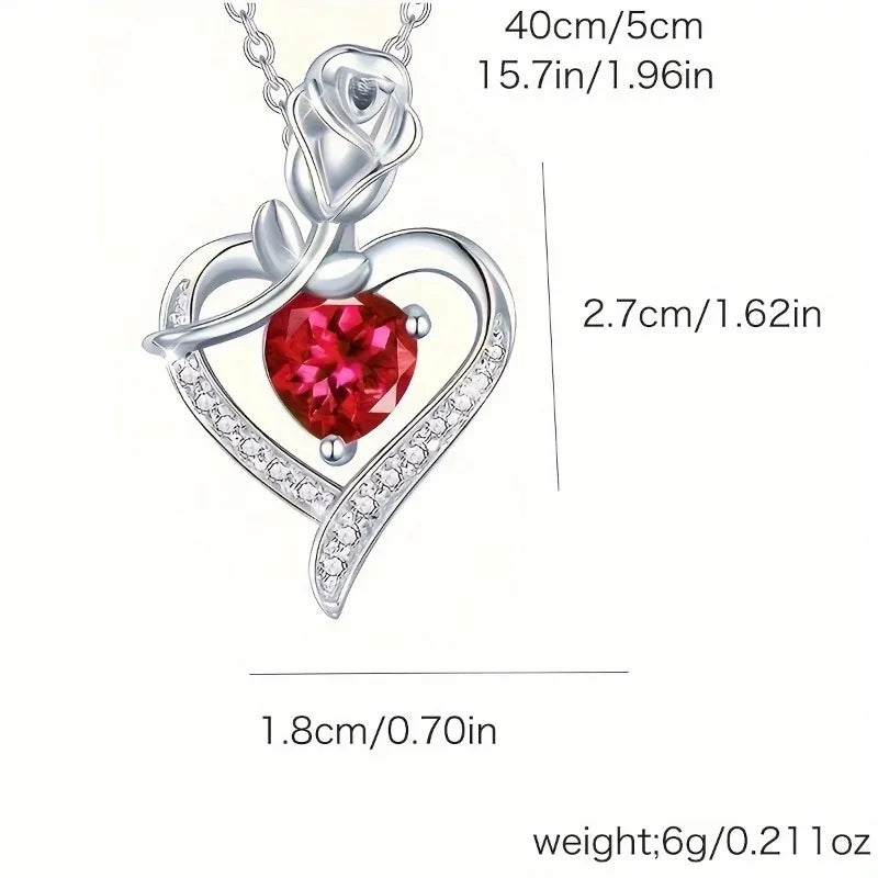 A silver pendant necklace featuring a rose design with a red heart gemstone and surrounding clear stones.