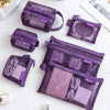 A collection of purple transparent mesh storage bags with zippers organized for coins, cards, and travel essentials.