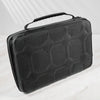A black portable leather watch travel case with a textured surface is shown on a white marble surface.