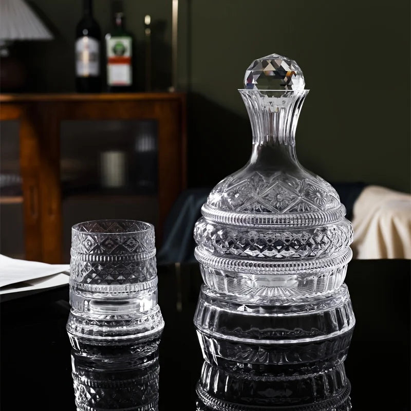 A clear crystal wine decanter with a decorative stopper and rotating aerator sits on a dark surface.